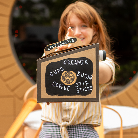 employee holding to go box of coffee