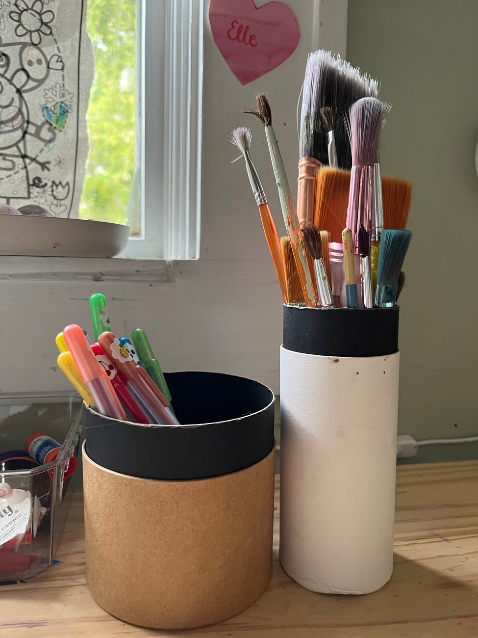 paint brushes and pencils in tea tubes