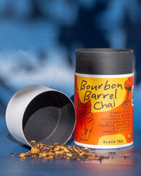 Bourbon Barrel Chai black tea canister with loose tea on a blue background