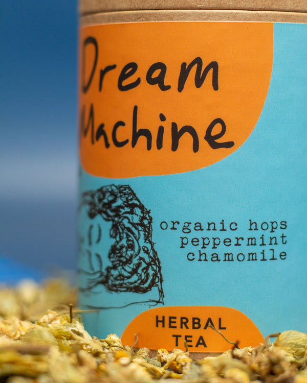 Tea packaging labeled 'Dream Machine' with herbs on a blue background