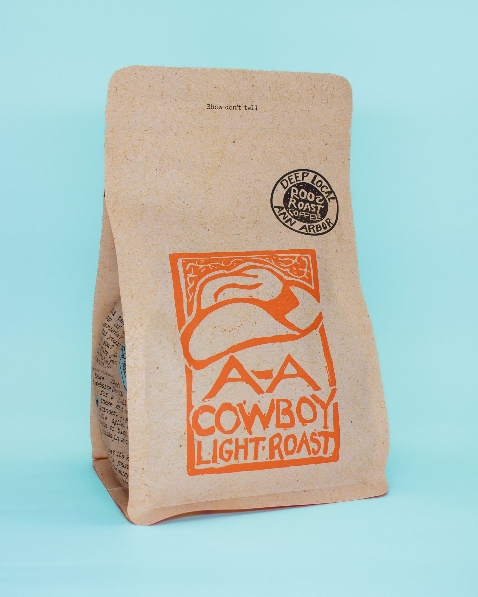 Kraft paper coffee bag with 'A bar A Cowboy Light Roast' branding on a light blue background