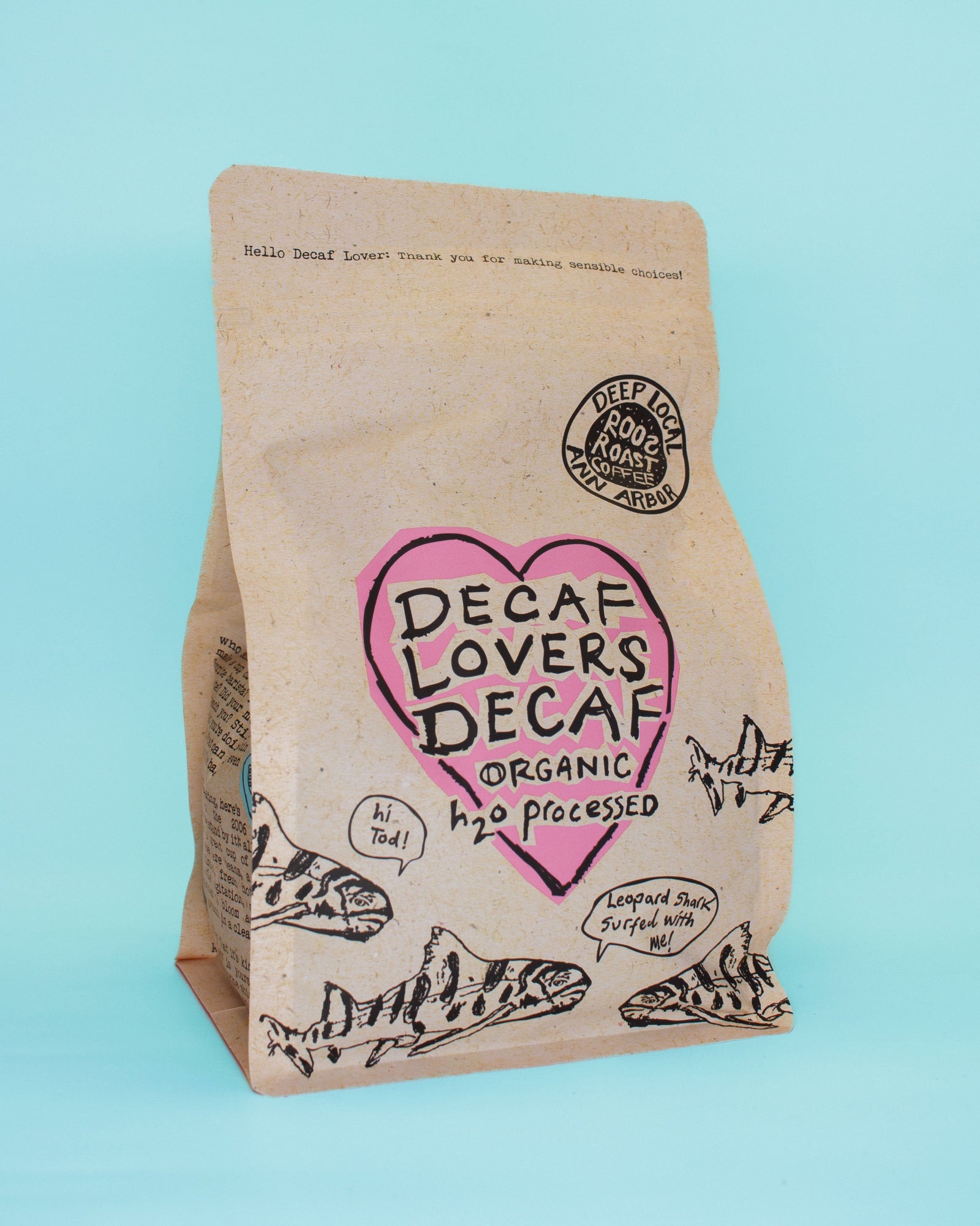 Decaf coffee bag with a heart-shaped logo on a light blue background