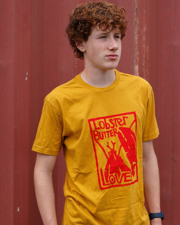 Person wearing a yellow t-shirt with a red graphic design against a red background