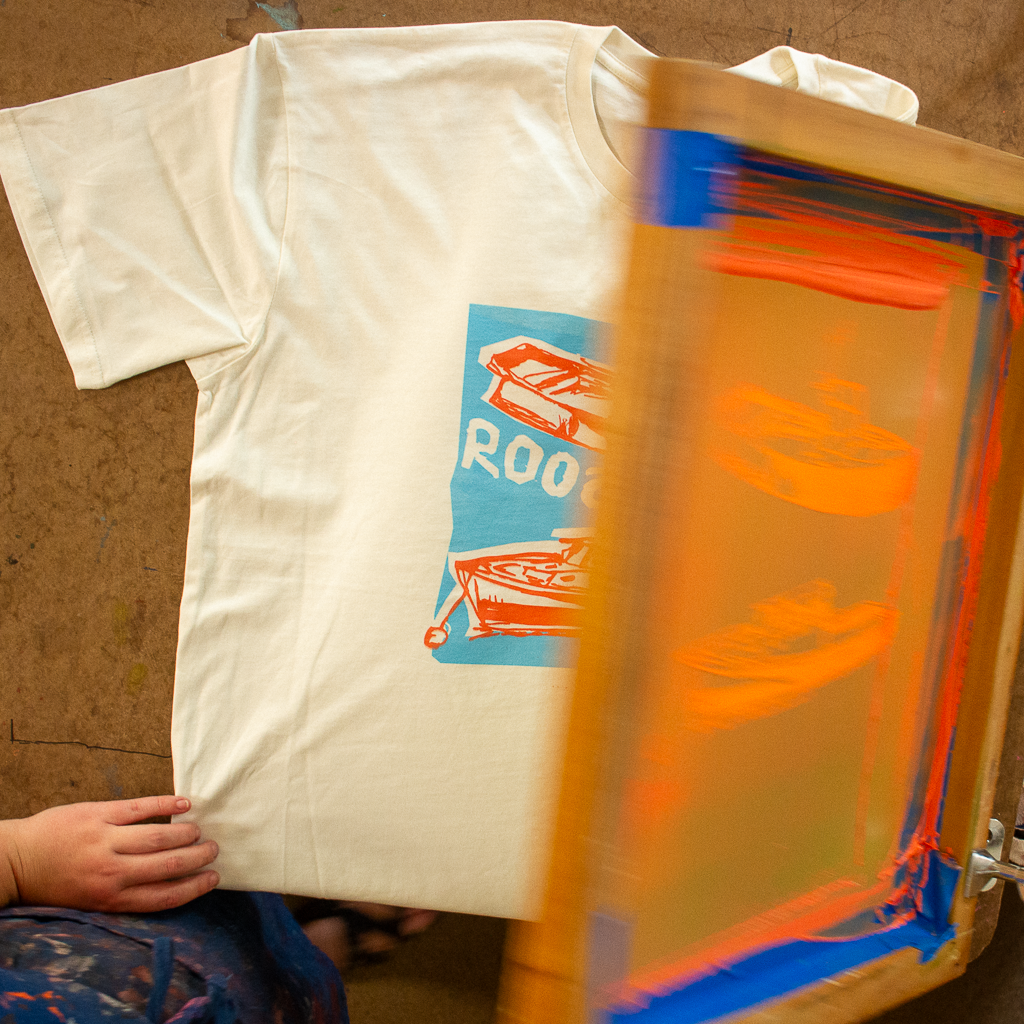 lifting the screen to reveal freshly printed t shirt