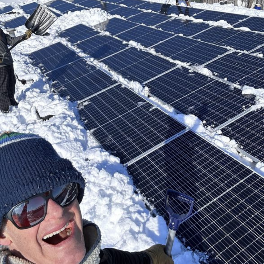 john roos on the roof with solar panels in winter