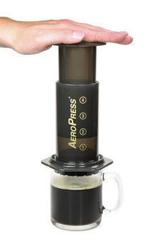 hand demonstrating aeropress the better coffee press coffee maker sold by RoosRoast Coffee in Ann Arbor Michigan